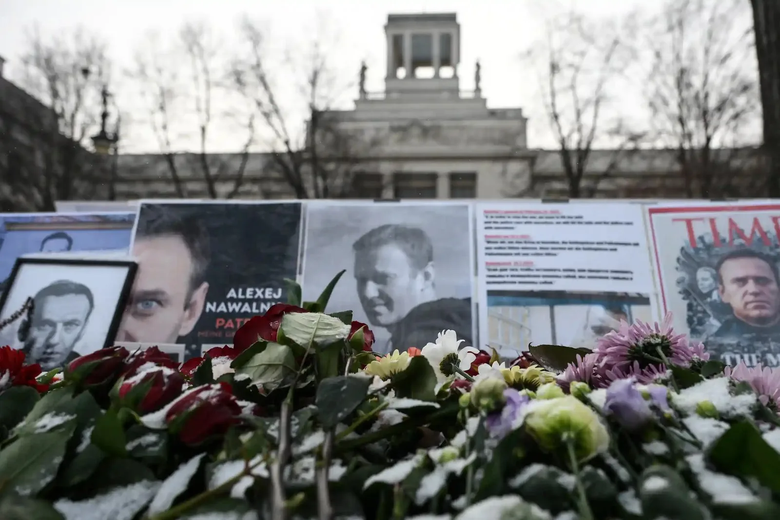 Flower lay in front of photos of a man.