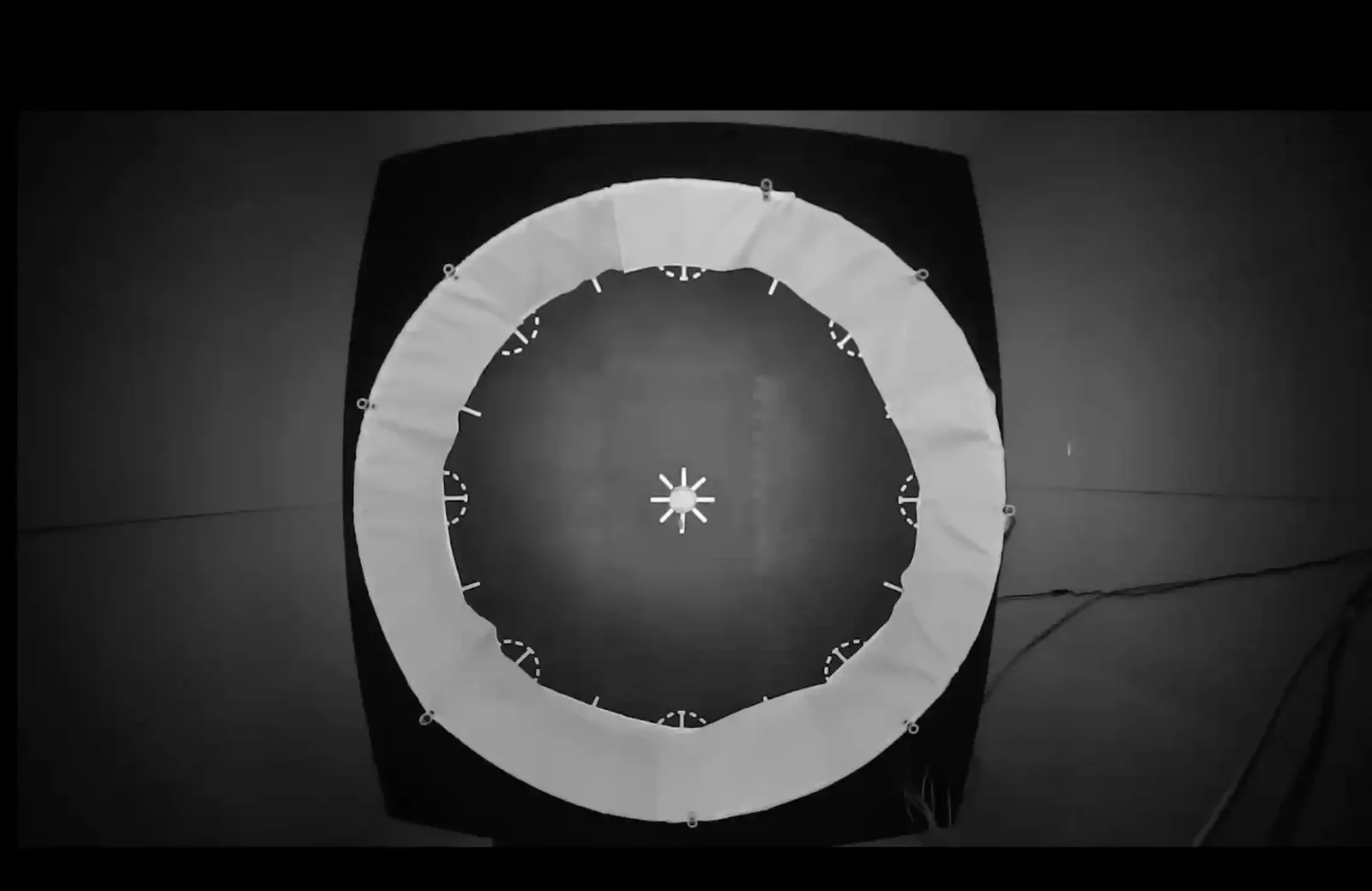 Black and white aerial view of a circular area with a white star in the middle