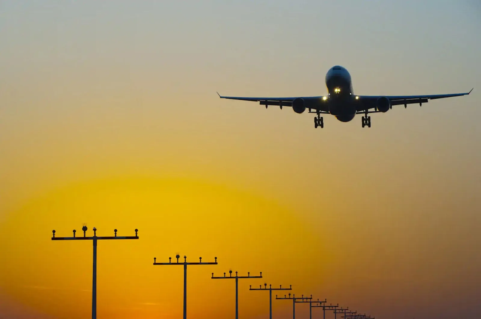 An aircraft landing at sunrise.