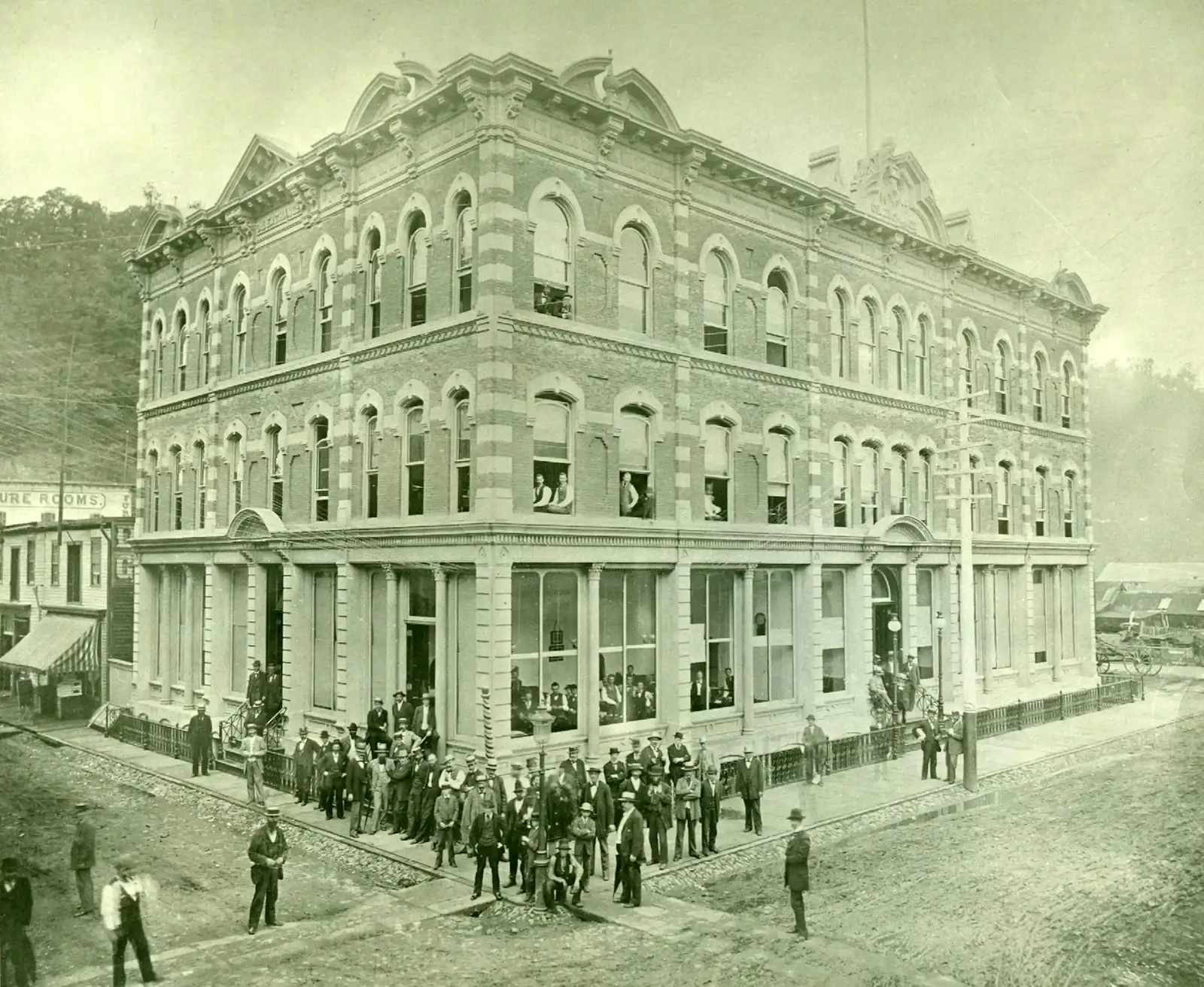 Businessmen are seen outside an ornate building in a black-and-white photo.