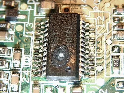 Failed IC in a laptop. Wrong input voltage has caused massive overheating of the chip and melted the plastic casing.