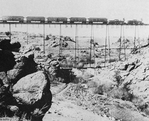 ABD'de "Vahşi Batı" denilen bölgede çift lokomotif tarafından çekilen vagonlar bir demiryolu köprüsü geçerken (1860'lı yıllar)