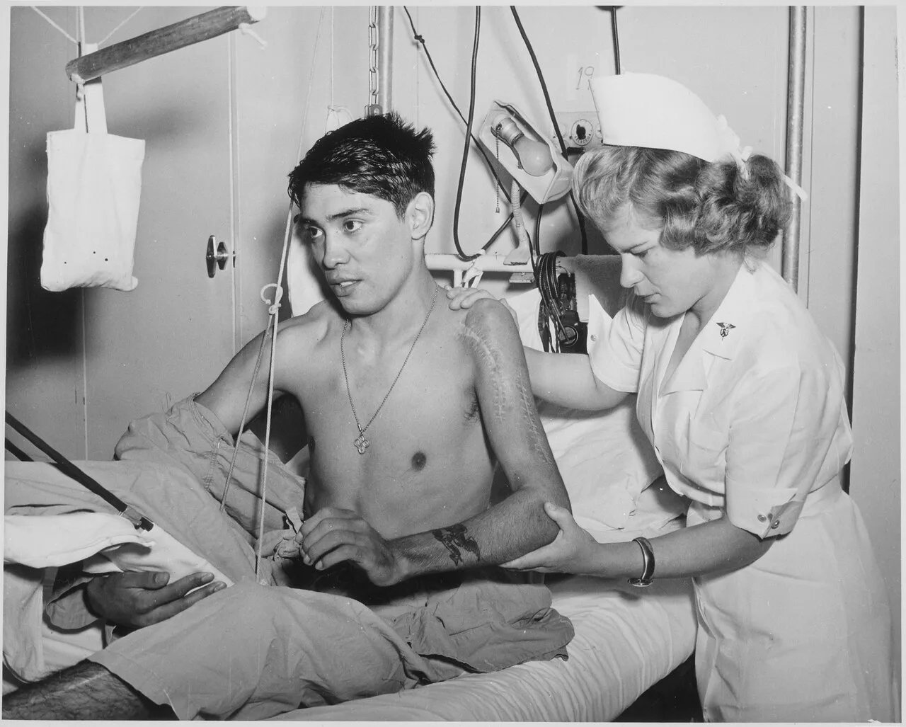 Exercising the shoulder and elbow to increase motion following the fracture and dislocation of the humerus is being given by an Army therapist to a soldier patient.