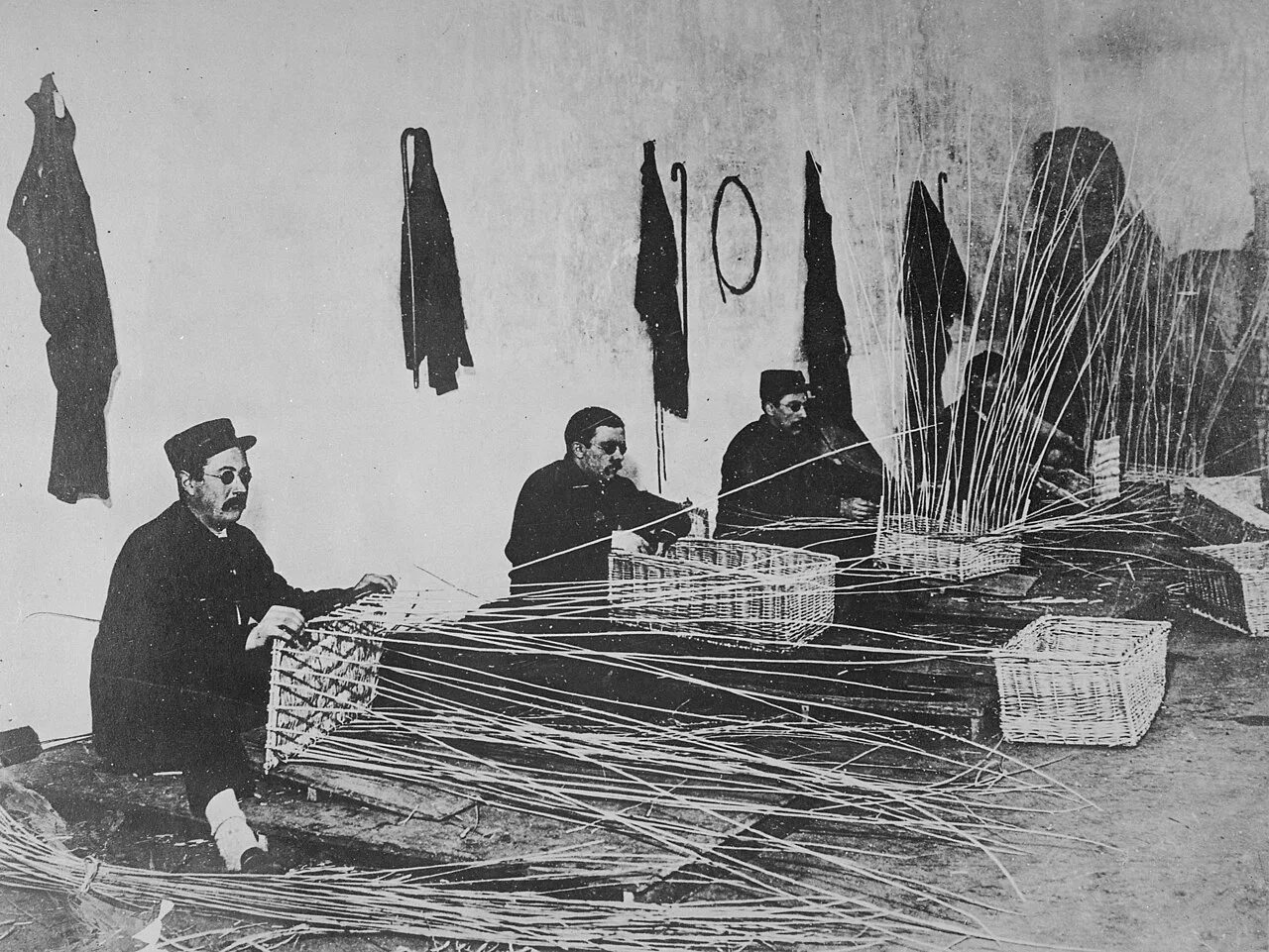 Re-educating wounded. Blind French soldiers learning to make baskets, World War I.