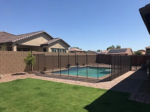 Newly installed removable mesh pool fence used to provide a protective barrier between children and the swimming pool