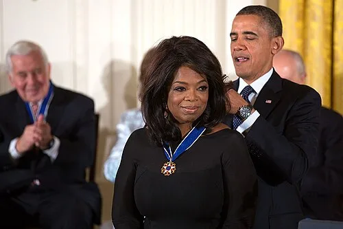 American entrepreneur, television host and media executive Oprah Winfrey receiving the Presidential Medal of Freedom from US President Barack Obama in 2013.
